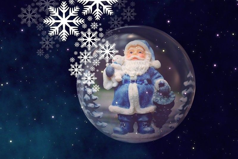Weihnachtsmann in einer Schneekugel mit Schneeflocken im Weltraum. Ein Weihnachtsmann in blauem Anzug in einer Schneekugel, umgeben von Schneeflocken und Sternenhimmel.